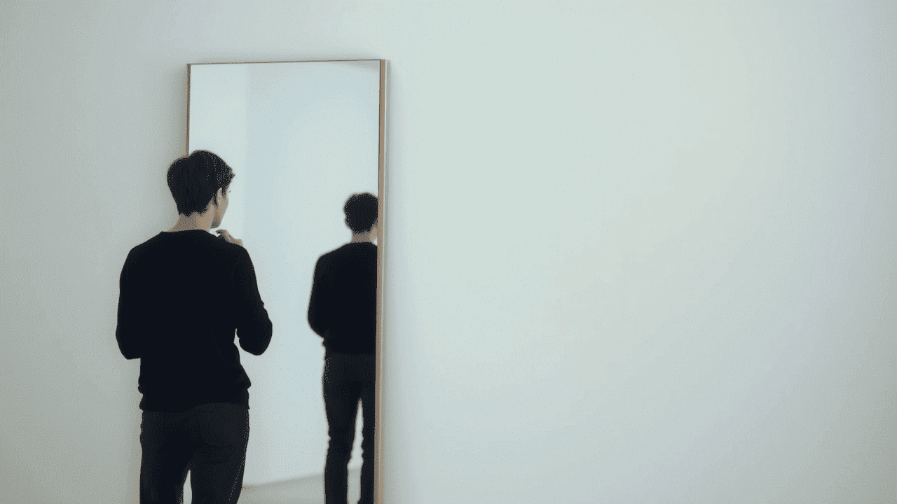 Persona reflexionando frente a un espejo